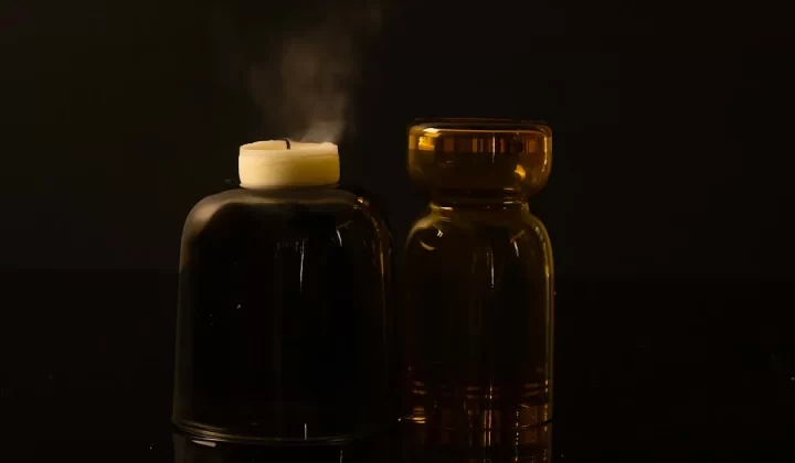 A candle and a bottle on a table